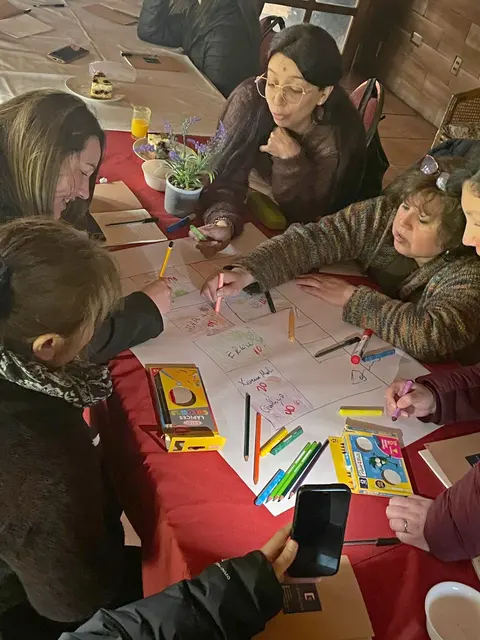 Trabajo en grupo con lápices de colores sobre un papelógrafo