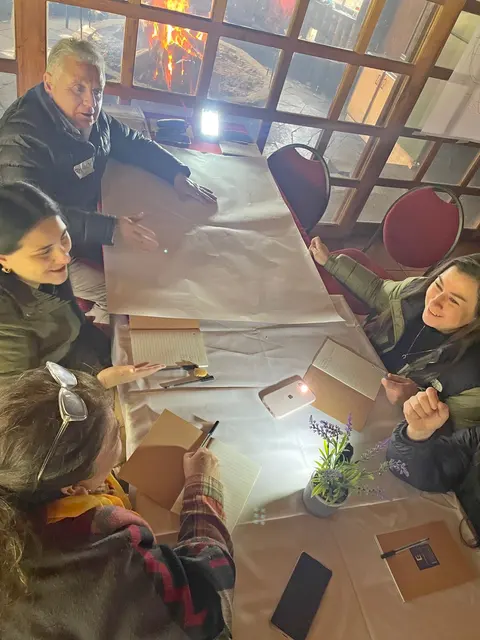 Participantes conversan alrededor de un papelógrafo