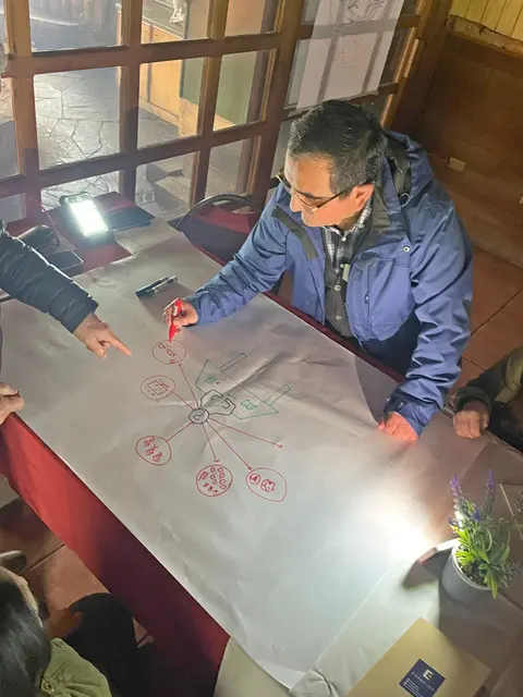 Una participante dibuja un esquema con plumón rojo