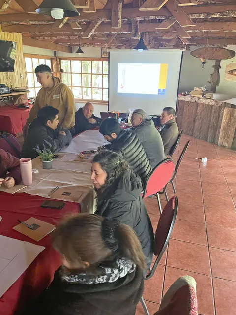 Salón del curso con las mesas de trabajo, el relator y la proyección