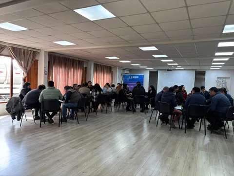 Participantes trabajan en grupos en el salón